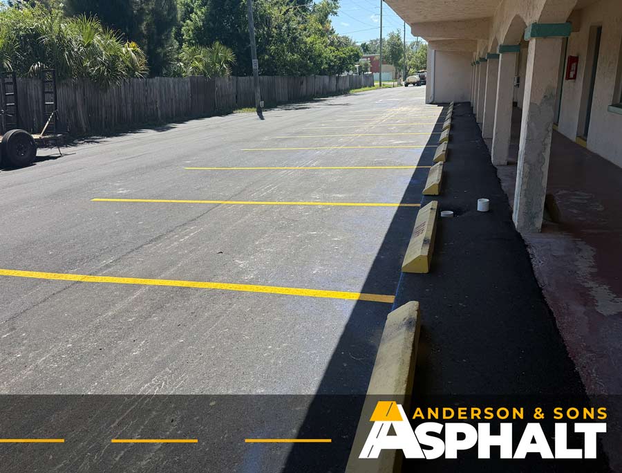 Finished asphalt parking lot with new yellow line striping after resurfacing