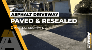 Newly resealed circular asphalt driveway in front of a yellow home