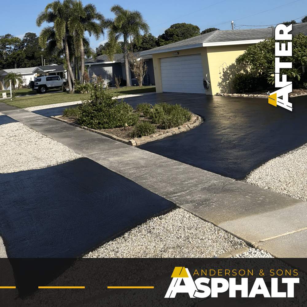 Freshly sealcoated black circular driveway and street apron around a landscaped island