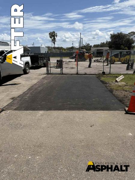 Finished asphalt patch connecting two paved lot sections where grass previously stood