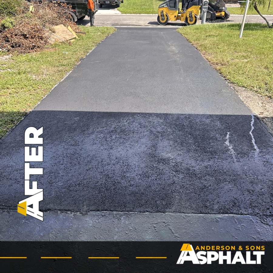 Freshly paved asphalt driveway with a roller at the street