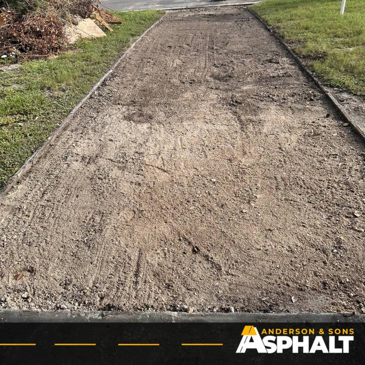 Driveway with old asphalt removed down to the base, ready for new paving
