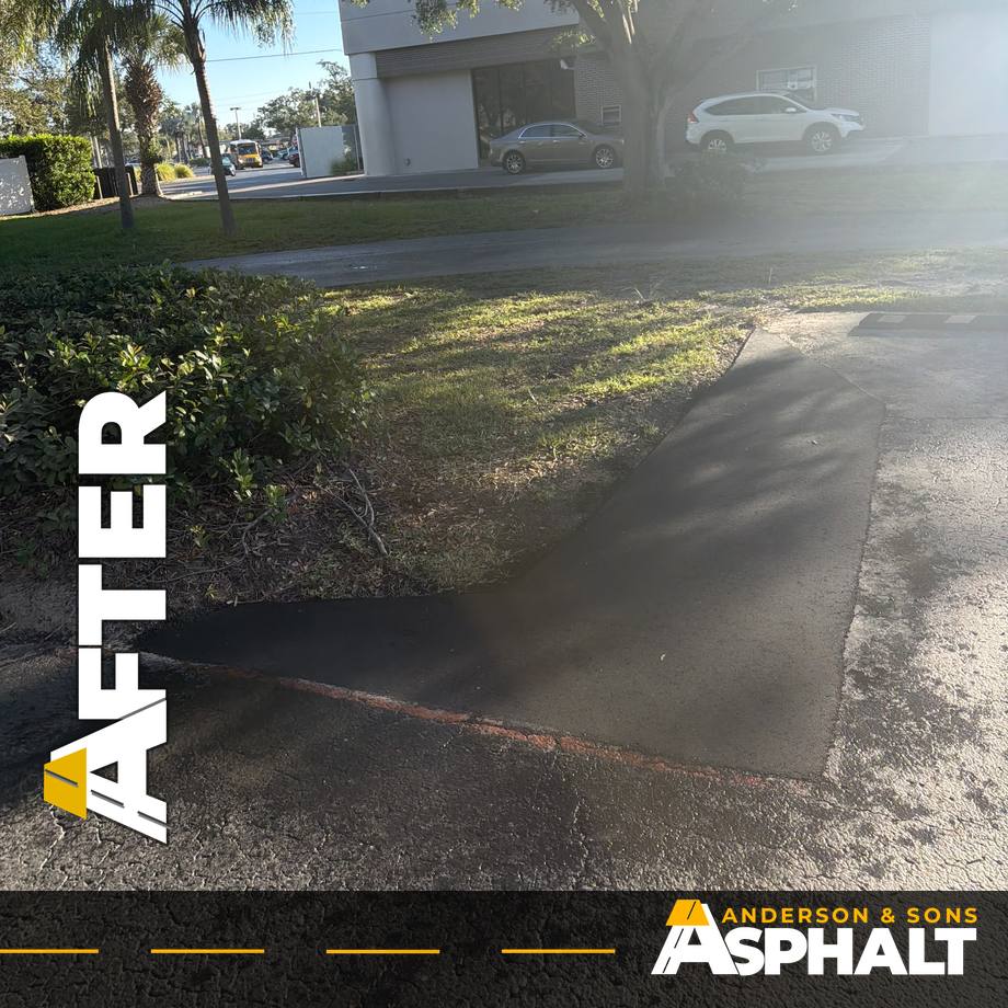 Finished asphalt patch along a landscaped island, flush with the existing parking lot